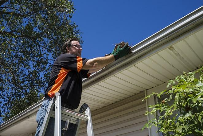 gutter repair technician using a power drill in Brea